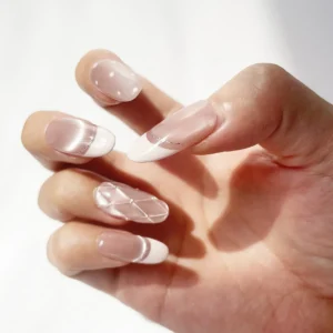 Soft pink cat eye press-on nails with French tips on right hand