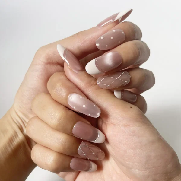 Soft pink cat eye press-on nails with French tips on finger