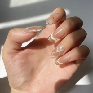 Left hand modeling rose gold-pink cat eye press-on nails with gold French tips