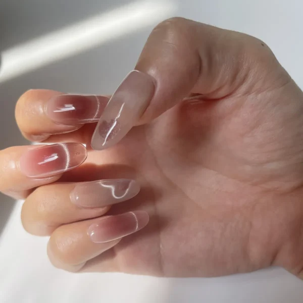 Pink fake nails with heart cat eye effect & soft shimmer on right hand
