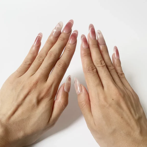 Pink cat eye press-on nails with heart shimmer effect on finger