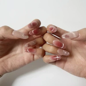 Pink cat eye heart shimmer press-on nails modeled on finger