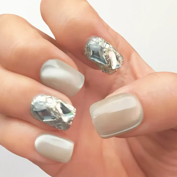 Close-up of 3D handmade champagne gold cat eye fake nails with crystal rhinestones