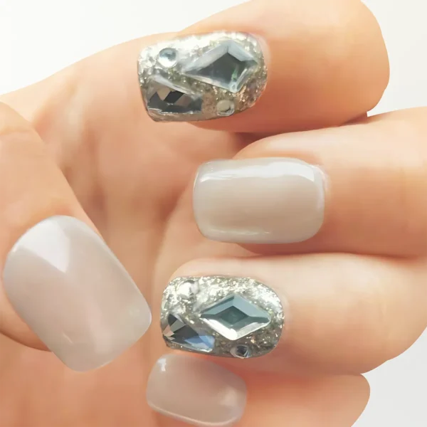 Left hand modeling champagne gold cat eye press-on nails with crystal accents