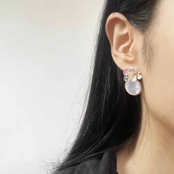Model wearing natural mother-of-pearl clip-on earrings with silver flowers